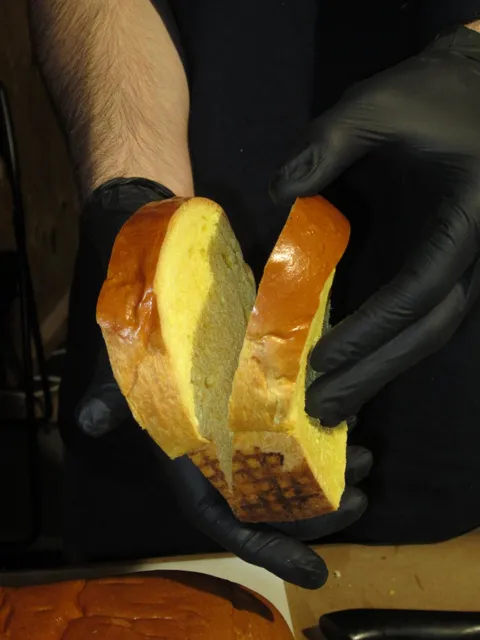 Manos rellenando un bocadillo