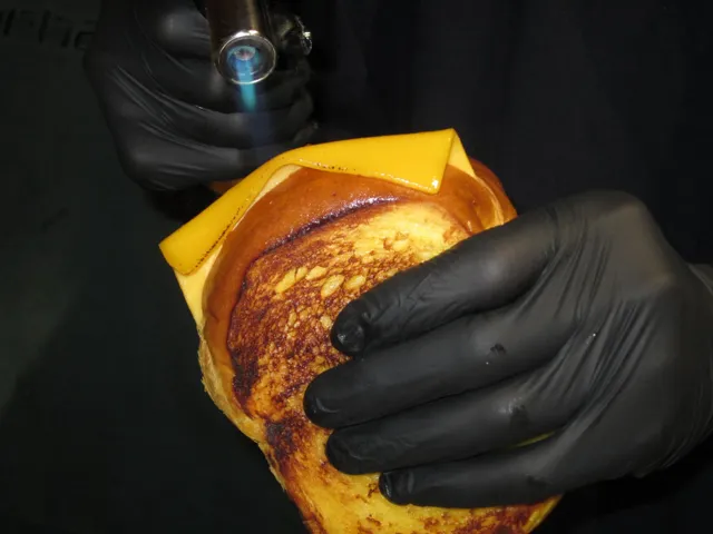 Primer plano de un bocadillo sostenido con guantes