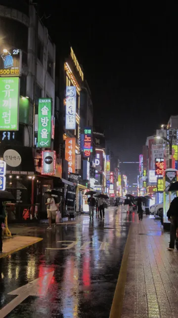 Calle iluminada de noche y pavimento mojado