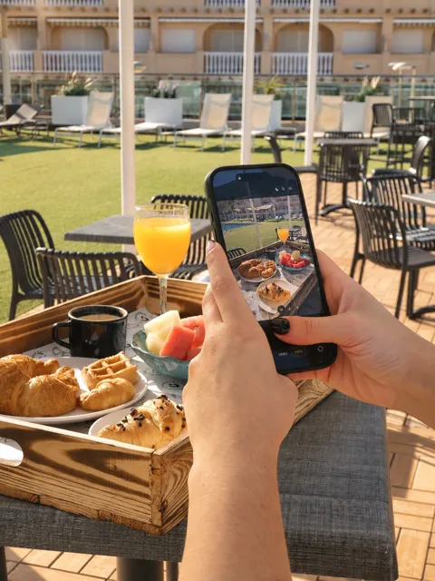 Una persona fotografía un desayuno con su teléfono