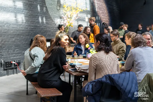 Asistentes conversando en una mesa al aire libre