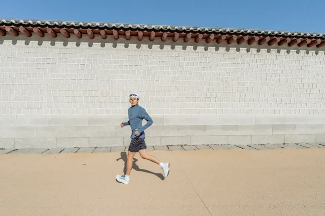Una persona con ropa deportiva junto a un muro