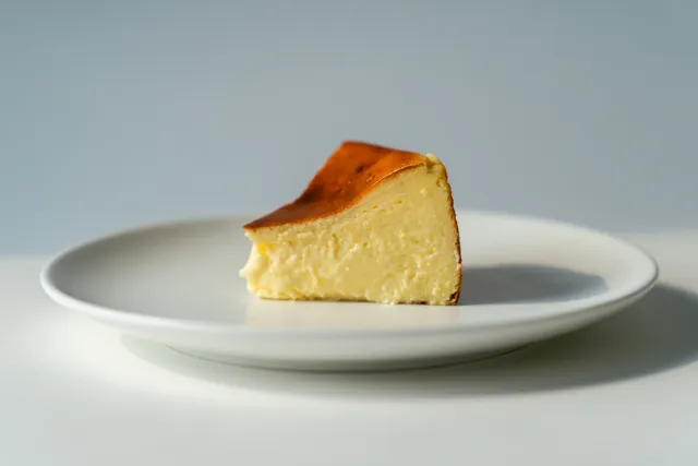 Porción de tarta de queso sobre un plato blanco
