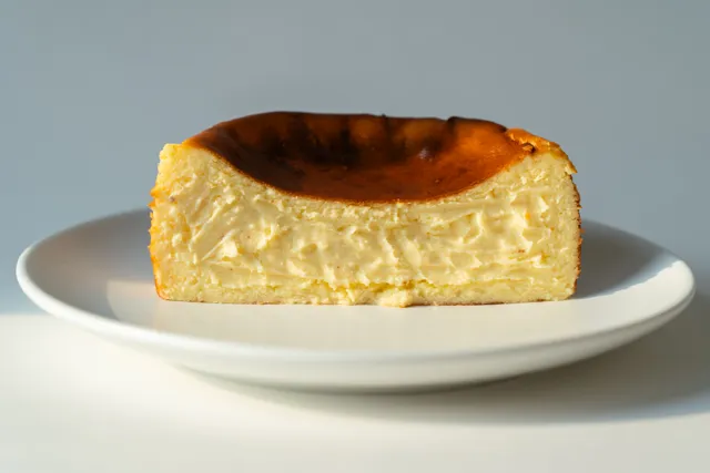 Porción de tarta de queso sobre fondo neutro