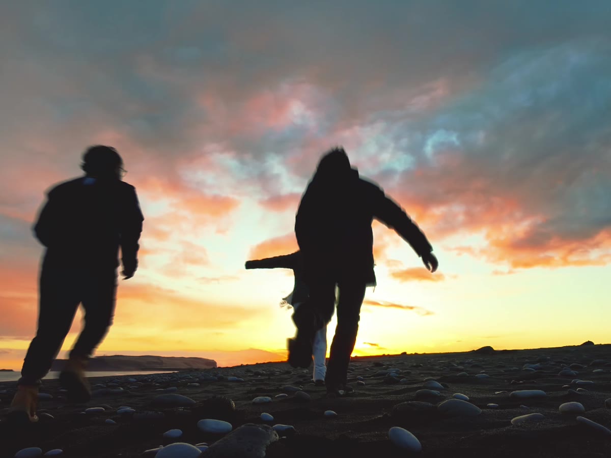 Dos figuras en silueta frente a un atardecer