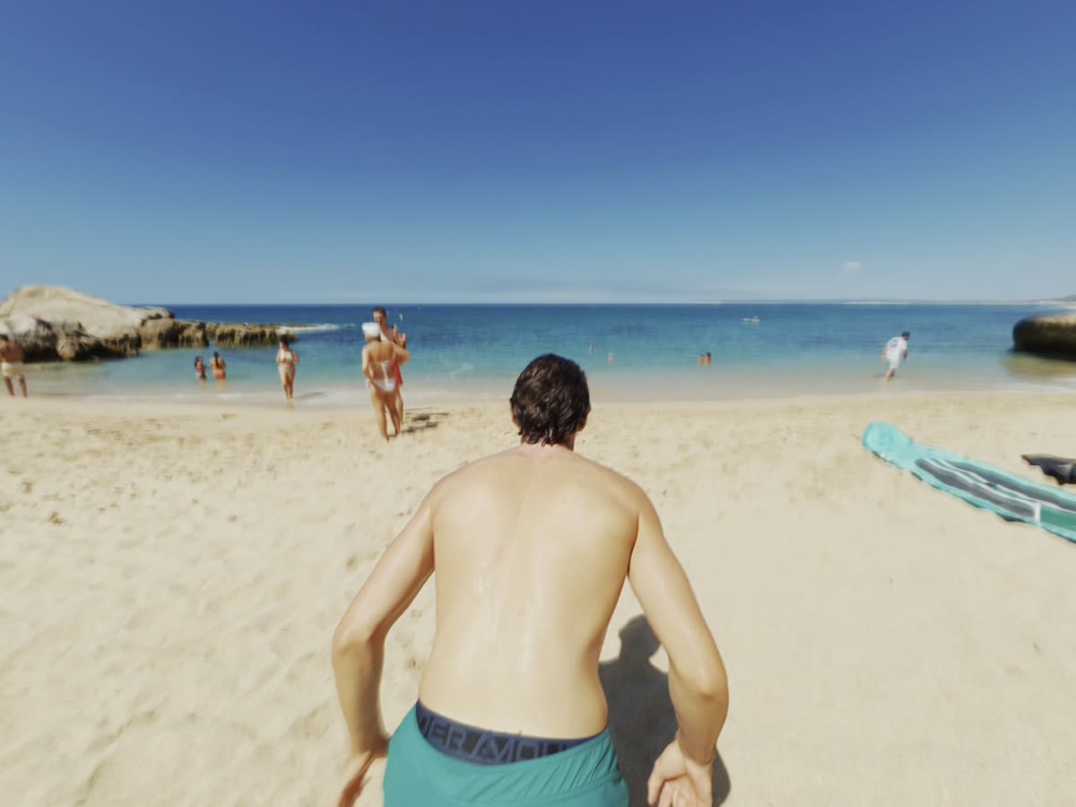 Una persona entrando al agua en una playa